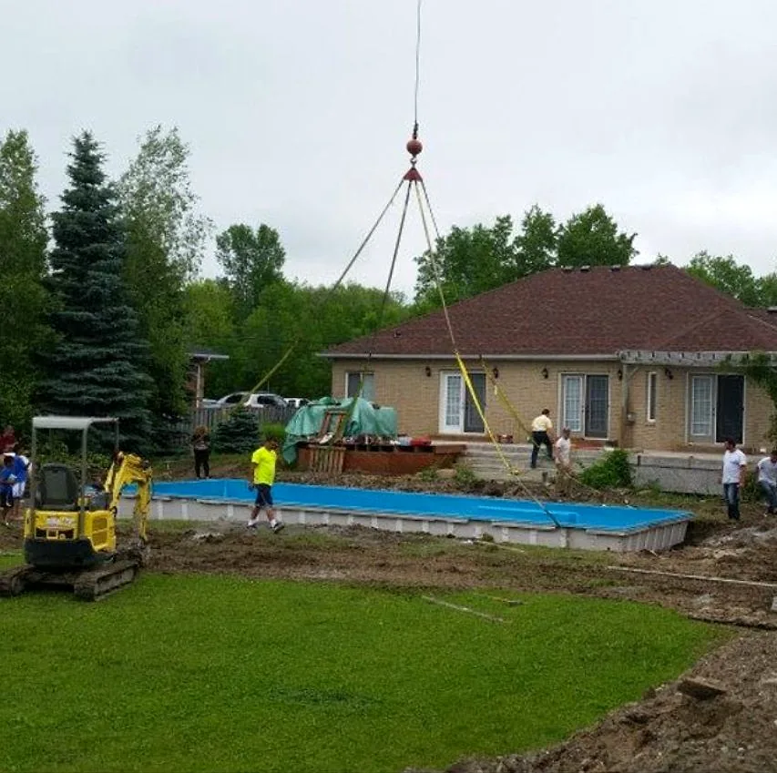 A pool shell being craned into a backyard on an ACL Pools job